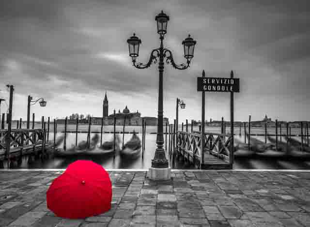Heart shaped umbrella next to lamp post at Gondola hiring point, Venice, Italy
